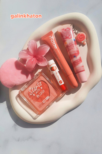 > پک آرایشی صورتی دخترانه شامل لیپ اویل توتفرنگی، بستنی لب فانتزی و رژگونه هلویی؛ چیدمان فلتلی لوکس و مینیمال با تم دخترانه و ترند ۲۰۲۵