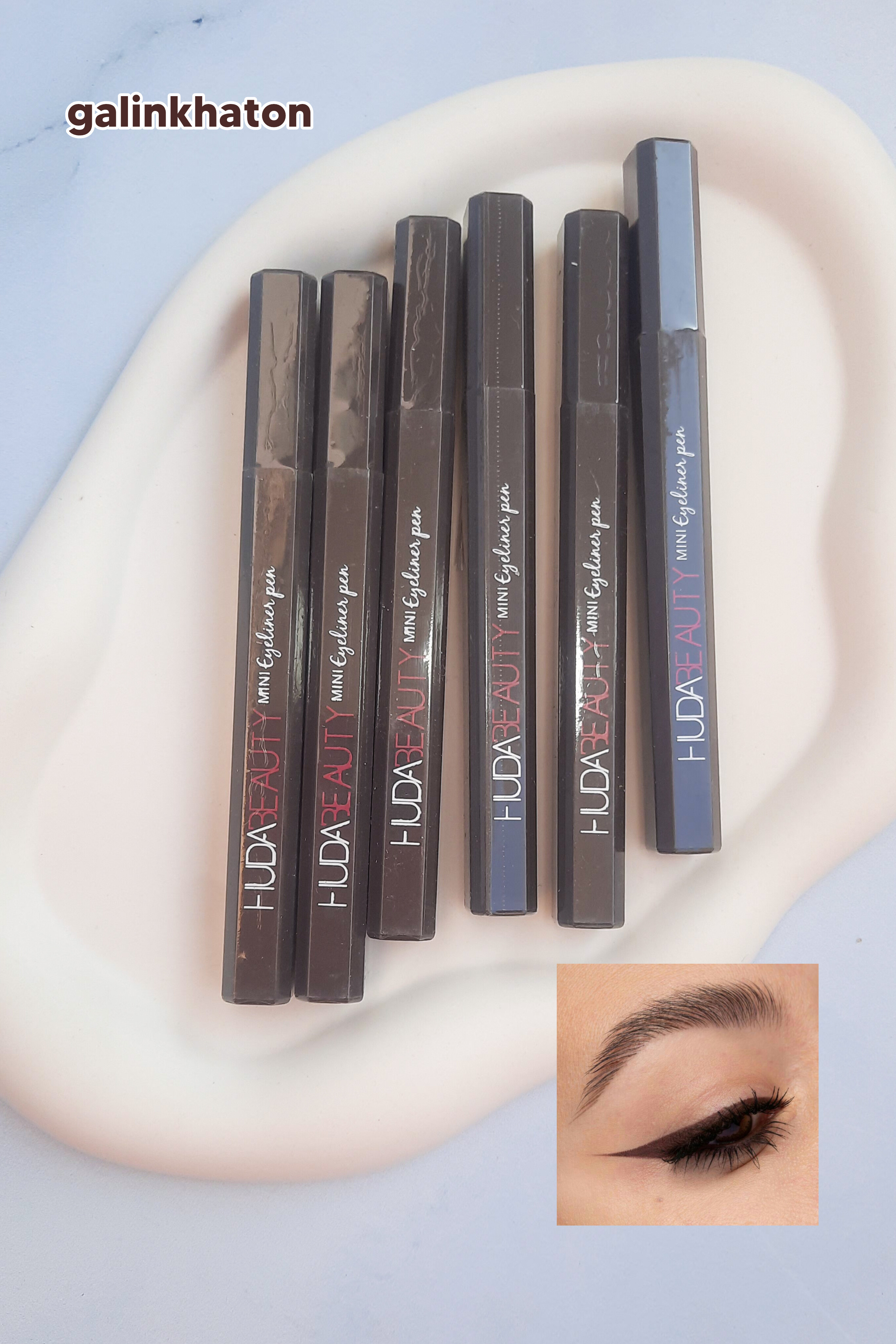 «شش خط چشم ماژیکی قهوه‌ای HUDA BEAUTY کنار هم روی شیپ سنگی سفید، با پوشش دقیق و رنگ طبیعی برای چشم‌های جذاب و حرفه‌ای.»