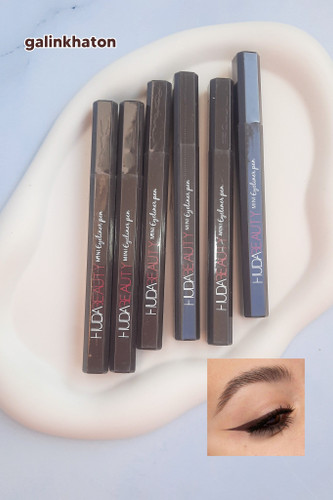 «شش خط چشم ماژیکی قهوهای HUDA BEAUTY کنار هم روی شیپ سنگی سفید، با پوشش دقیق و رنگ طبیعی برای چشمهای جذاب و حرفهای.»