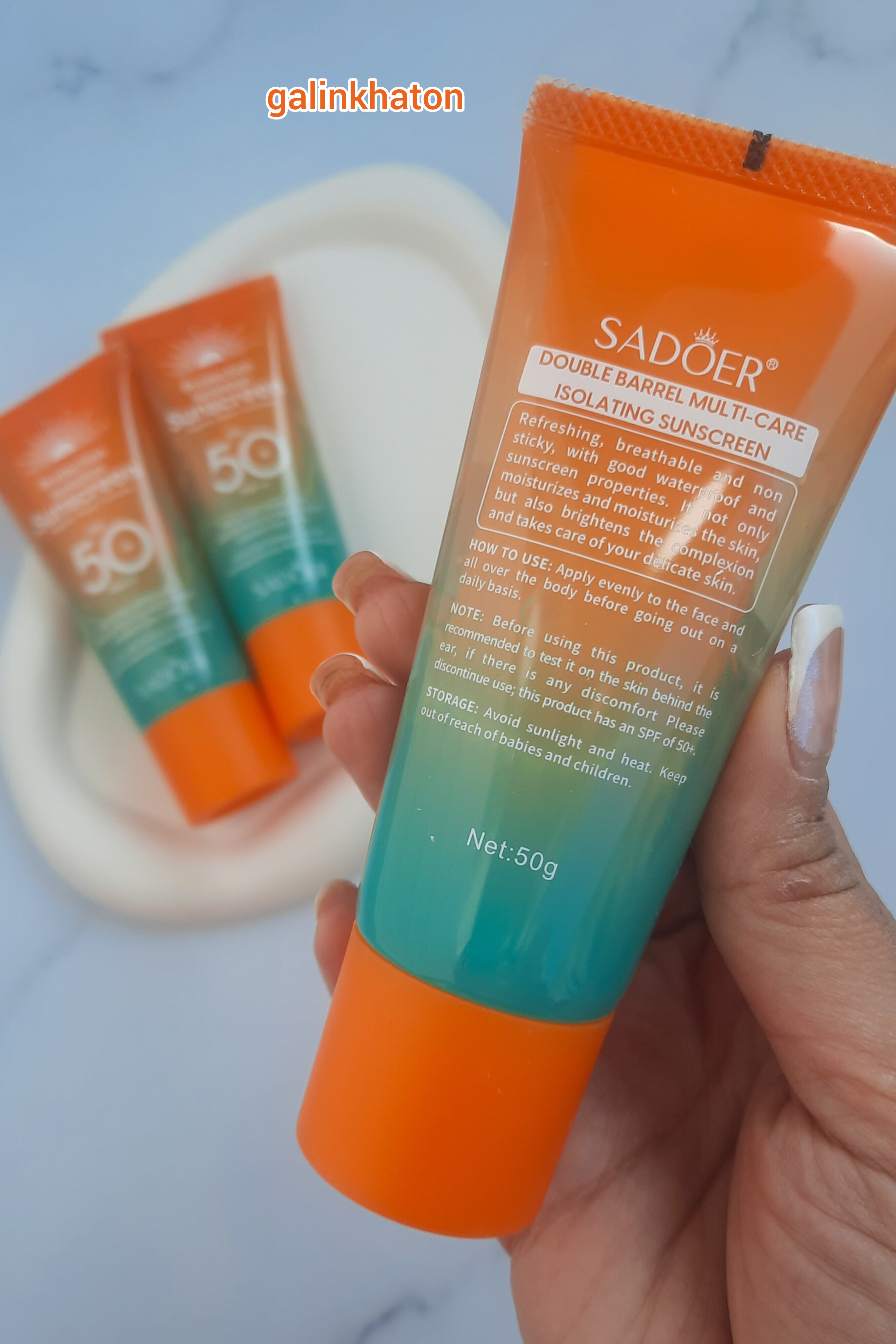 دو ضدآفتاب سادور SPF50 روی شیپ سنگی و یک ضدآفتاب در دست با نمای نزدیک برای نمایش نوشته‌های پشت محصول