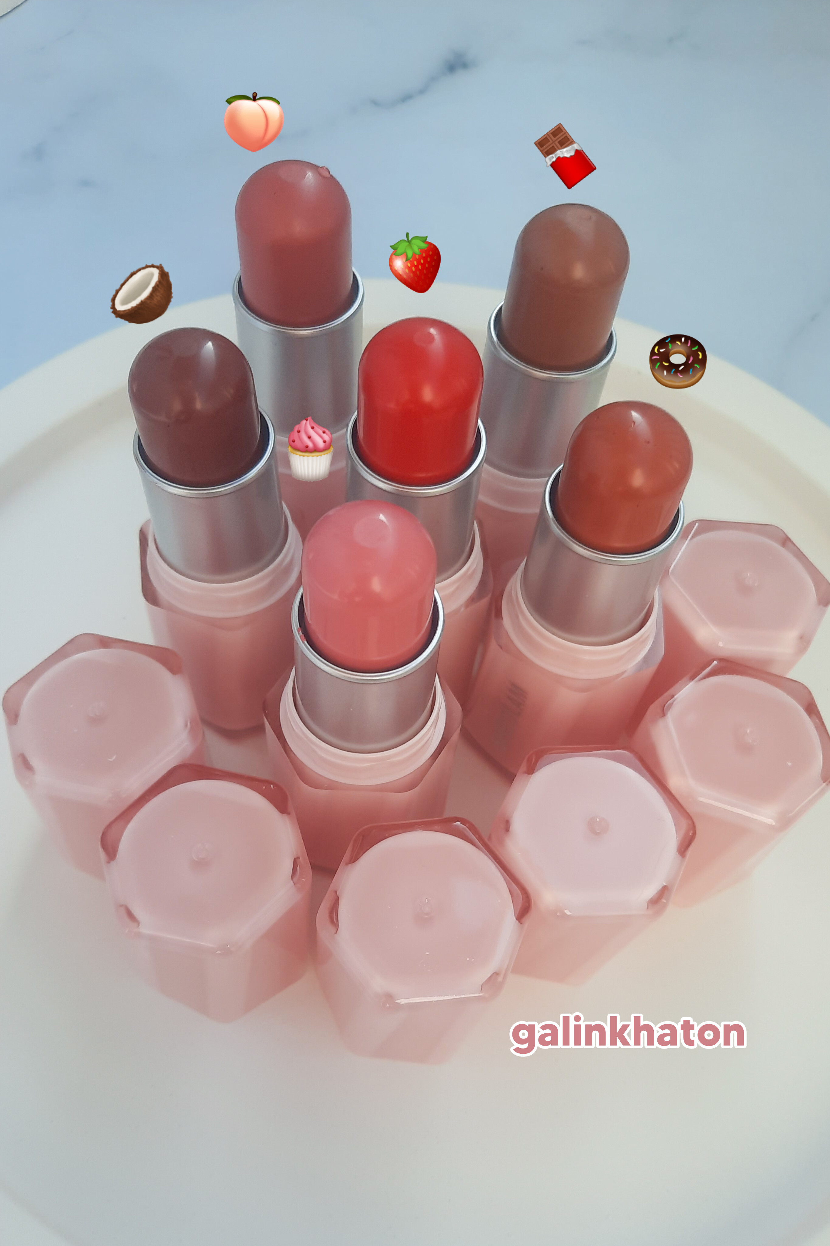 ۶رژگونه کره‌ای Sheglam درب‌باز از نمای بالا روی شیپ سنگی سفید برای نمایش تناژ رنگ