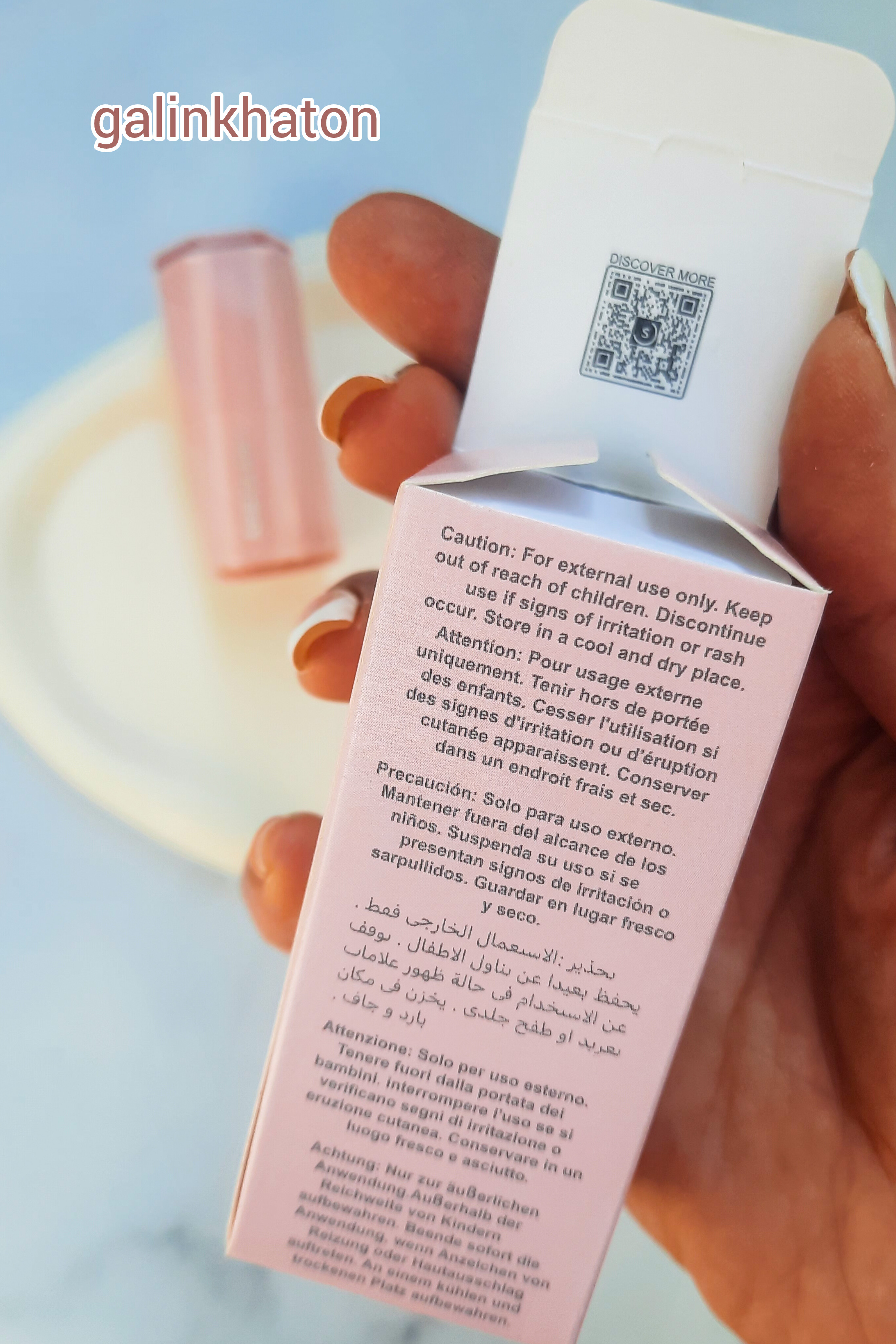 رژگونه Sheglam روی سنگ سفید همراه جعبه در دست، نمایش بارکد اسکن برای اصالت کالا