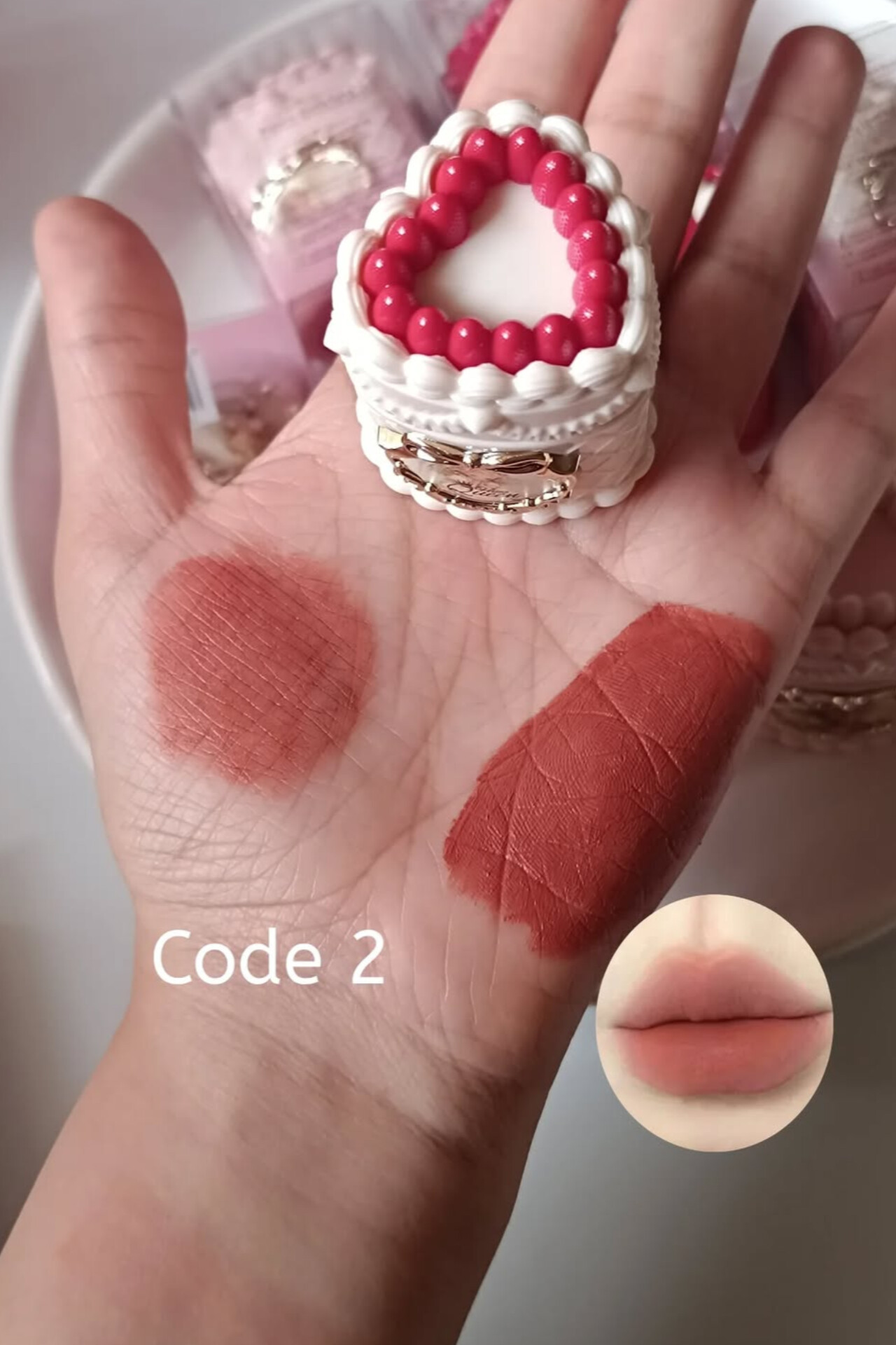 موس لب کیک توت فرنگی روی کف دست، تست رنگ ژرنالی، نمای نزدیک و طبیعی، آرایش حرفه‌ای