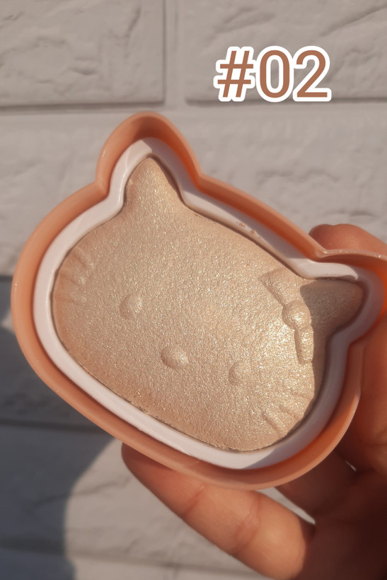 هایلایتر کیتی میس فون در دست، نمای نزدیک زیر نور طبیعی، بافت نرم و درخشان، مناسب آرایش حرفهای صورت