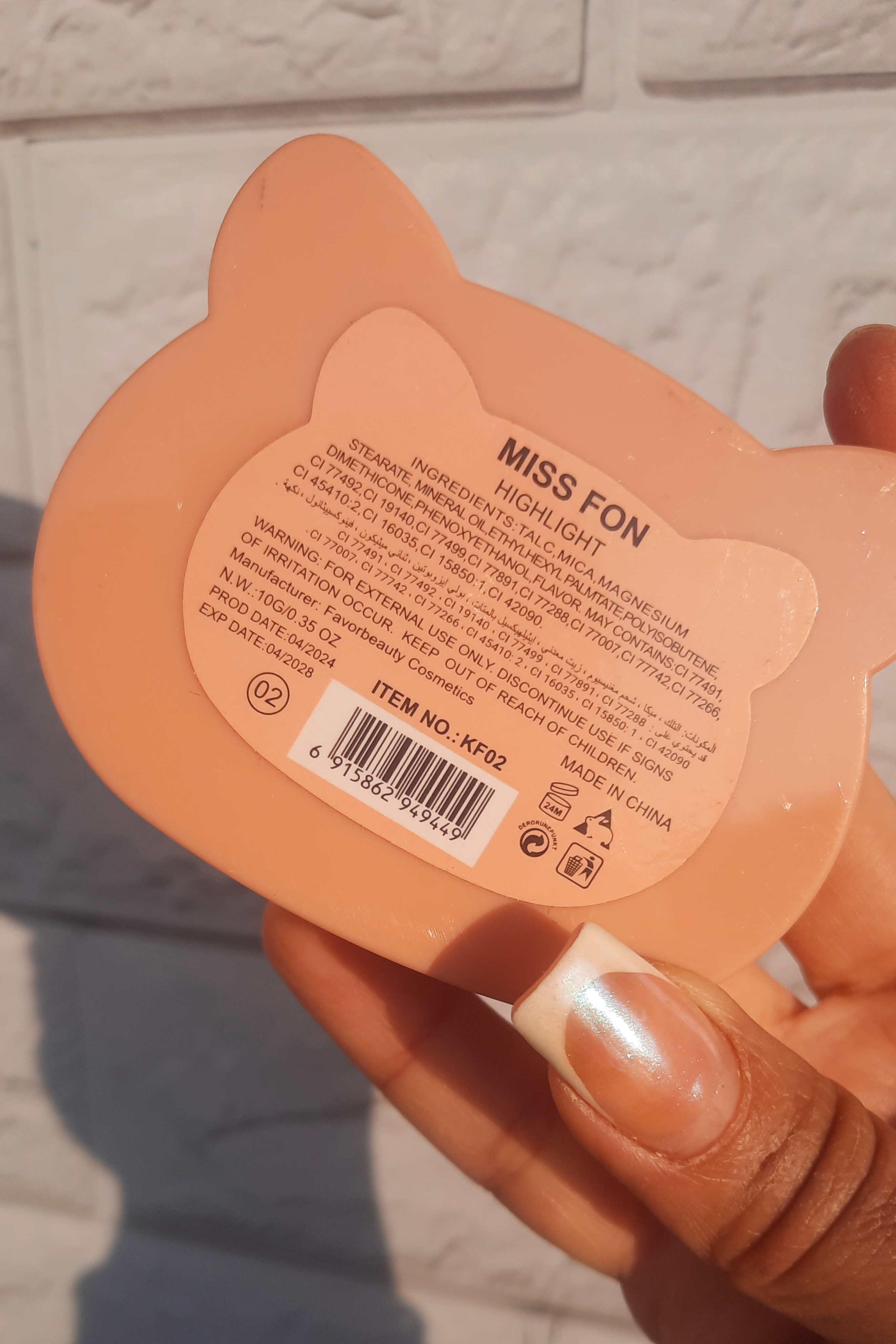 هایلایتر کیتی MISS Fon در دست، نمای نزدیک پشت محصول و نوشته‌ها، جزئیات بسته‌بندی و برند مشخص