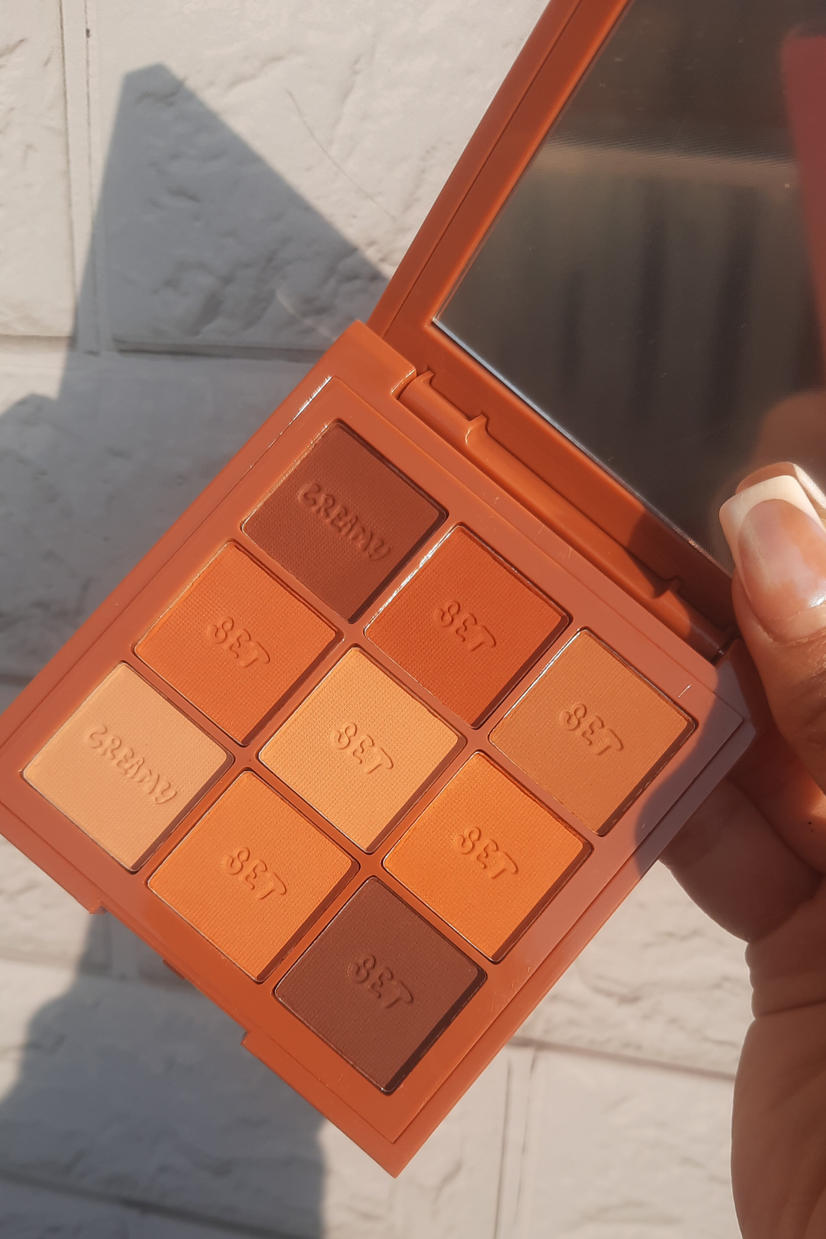 پالت سایه ۹ رنگ کرمی هدی موجی طیف نارنجی در نور آفتاب؛ رنگ‌های گرم و شاین‌دار برای میکاپ حرفه‌ای